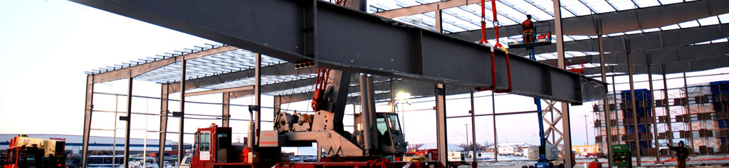 Metal building erectors lifting 15 ton beam